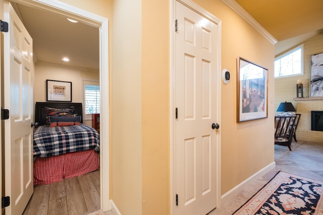 corridor featuring recessed lighting, light wood-style floors, baseboards, and ornamental molding