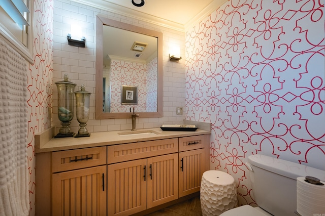 half bathroom featuring toilet, tile walls, crown molding, decorative backsplash, and vanity