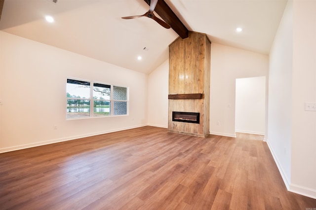 unfurnished living room with light wood finished floors, high vaulted ceiling, a fireplace, ceiling fan, and beamed ceiling