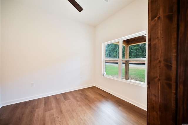 unfurnished room with a ceiling fan, wood finished floors, and baseboards