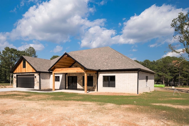 modern farmhouse with a front lawn, an attached garage, brick siding, and a shingled roof