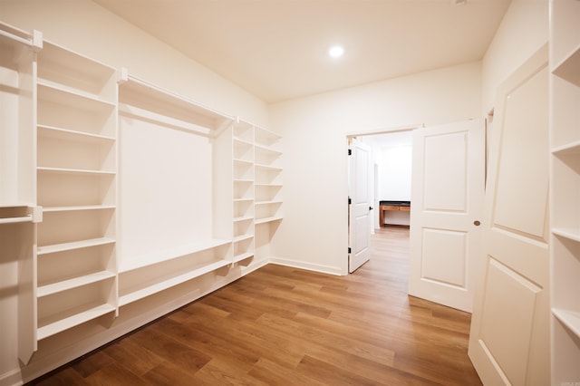 walk in closet with wood finished floors