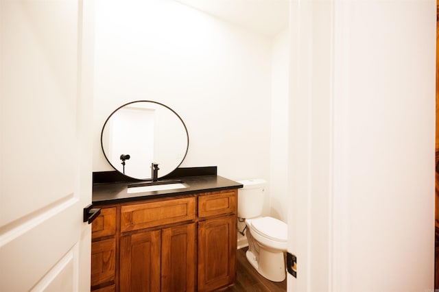 bathroom featuring vanity, toilet, and wood finished floors