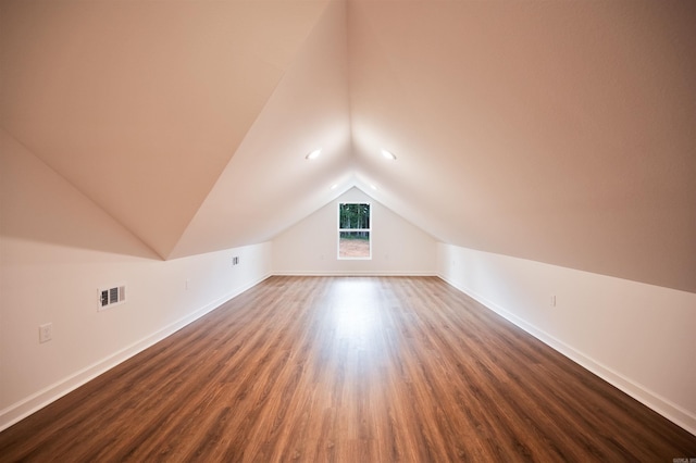 bonus room with visible vents, lofted ceiling, baseboards, and dark wood-style flooring