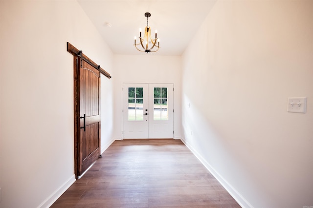 entryway featuring french doors, baseboards, a barn door, and wood finished floors