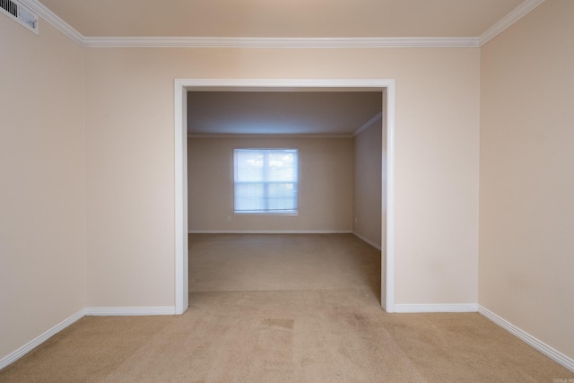 empty room with ornamental molding, baseboards, visible vents, and light carpet