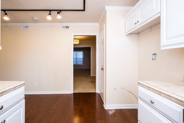 kitchen with dark wood-style floors, visible vents, tile countertops, and crown molding