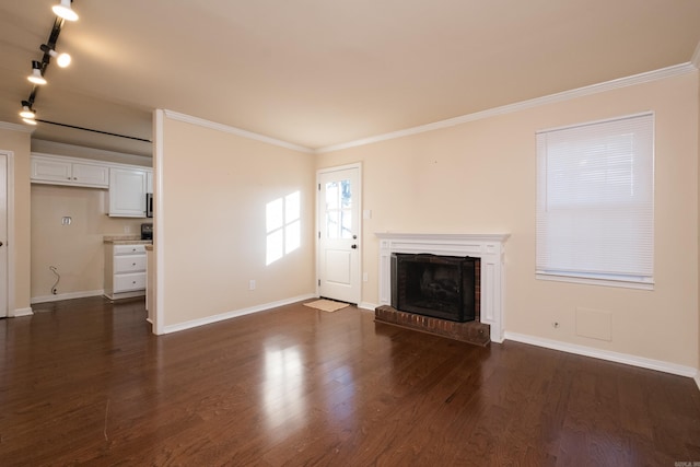 unfurnished living room featuring baseboards, a brick fireplace, dark wood-style floors, and crown molding