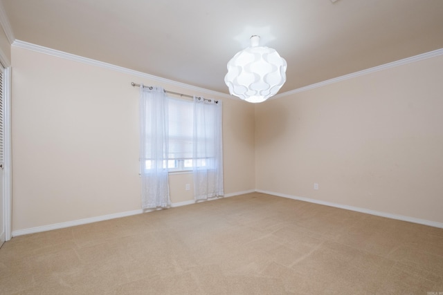 spare room with light colored carpet, baseboards, and ornamental molding