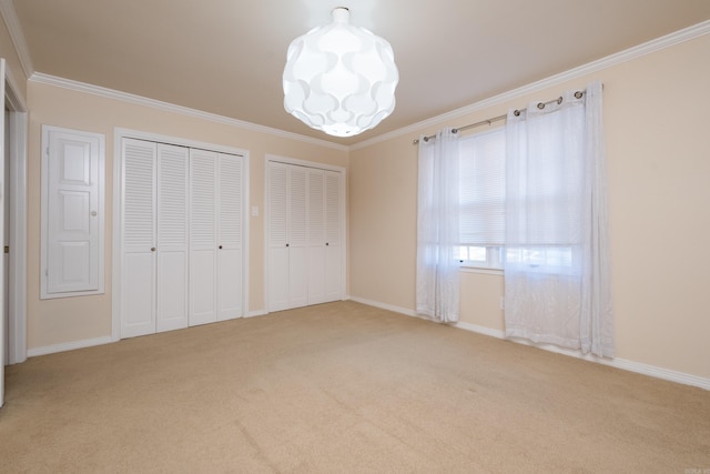 unfurnished bedroom with baseboards, light carpet, two closets, and ornamental molding