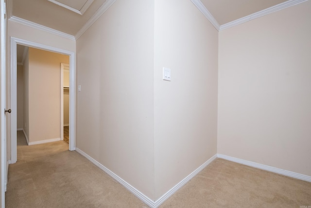 hall featuring crown molding, baseboards, and light carpet