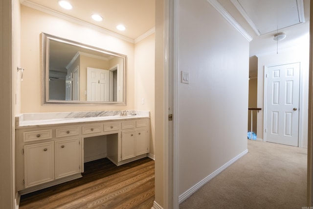 bathroom with wood finished floors, recessed lighting, crown molding, baseboards, and vanity