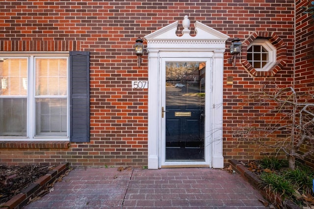 doorway to property featuring brick siding