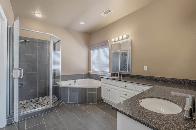 full bath featuring a sink, visible vents, a shower stall, and double vanity