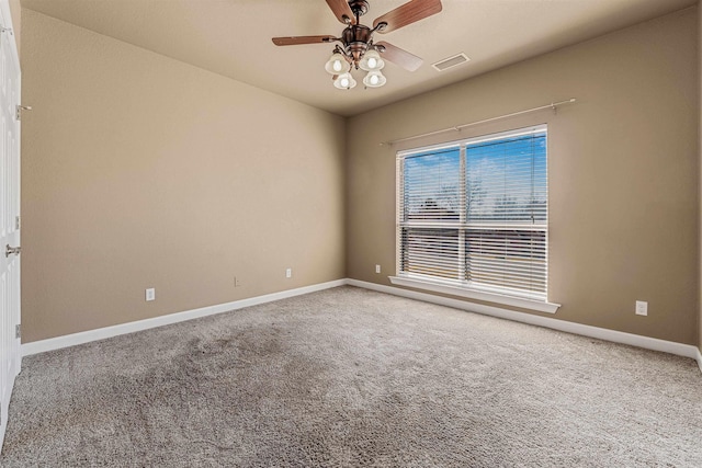 carpeted empty room featuring visible vents, baseboards, and ceiling fan