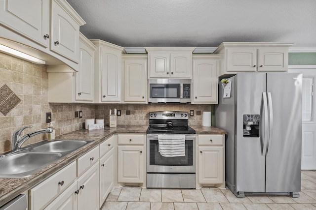 kitchen with decorative backsplash, light tile patterned flooring, appliances with stainless steel finishes, and a sink