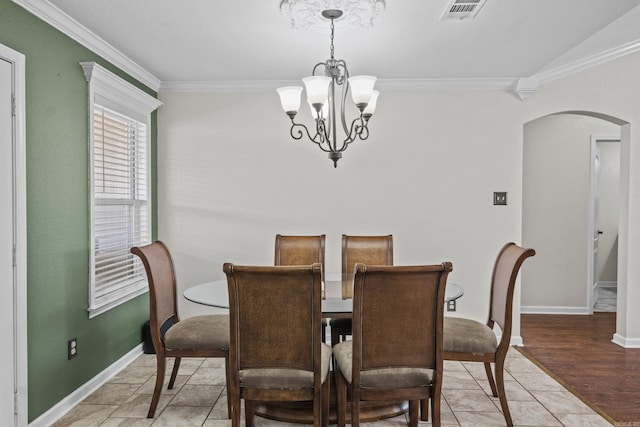 dining room with visible vents, baseboards, a chandelier, ornamental molding, and arched walkways