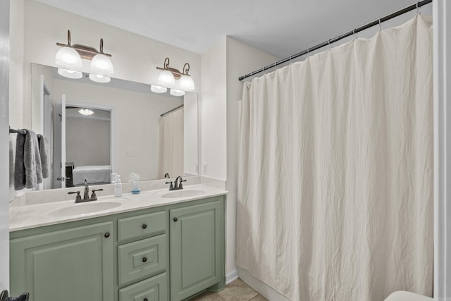 ensuite bathroom featuring double vanity, tile patterned floors, ensuite bathroom, and a sink