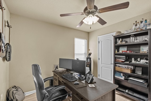 office with light wood-style flooring, baseboards, and a ceiling fan