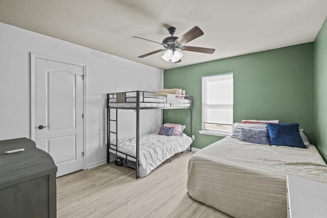 bedroom with baseboards, ceiling fan, and wood finished floors