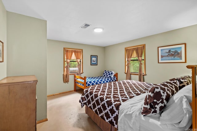 bedroom featuring visible vents, multiple windows, concrete floors, and baseboards