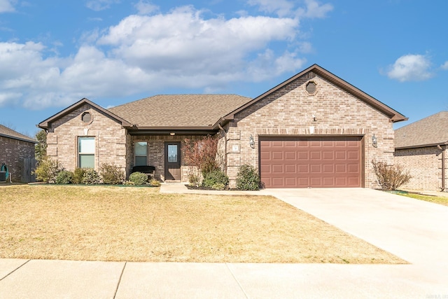 view of front facade with brick siding, concrete driveway, roof with shingles, a front yard, and an attached garage