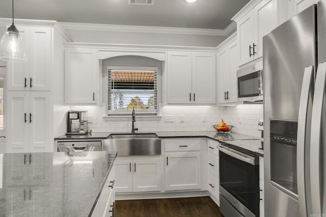 kitchen with visible vents, a sink, ornamental molding, stainless steel appliances, and white cabinets