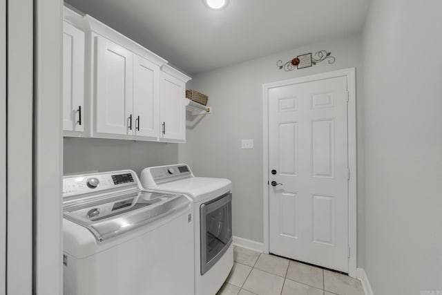 laundry room with light tile patterned floors, cabinet space, baseboards, and separate washer and dryer