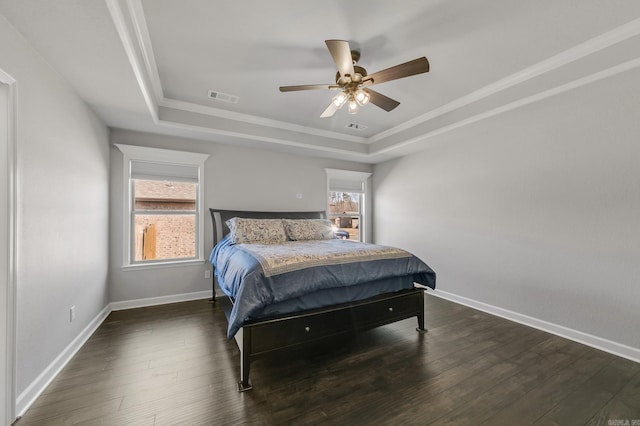 bedroom featuring visible vents, baseboards, dark wood-style floors, a raised ceiling, and a ceiling fan