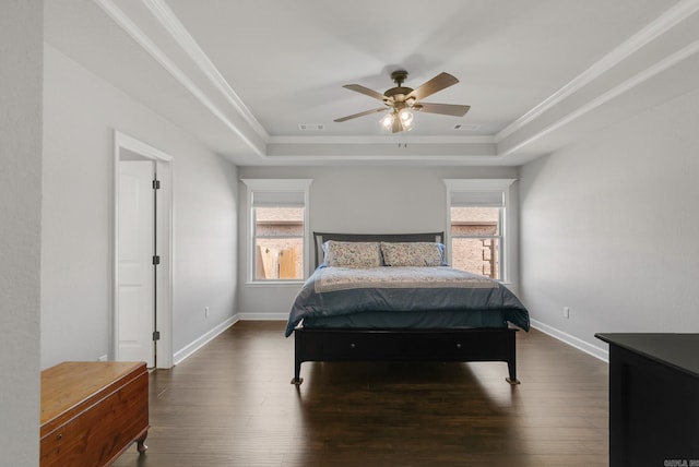 bedroom featuring a tray ceiling, multiple windows, and dark wood-style floors