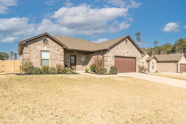 view of front of home with a front lawn, roof with shingles, concrete driveway, a garage, and brick siding