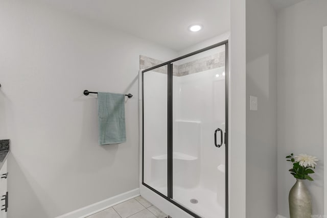 bathroom with tile patterned floors, a shower stall, vanity, and baseboards