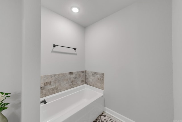 bathroom with baseboards and a bath