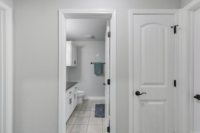 bathroom featuring vanity, baseboards, visible vents, tile patterned floors, and toilet