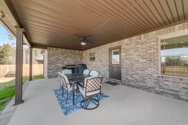 view of patio featuring area for grilling, outdoor dining space, a ceiling fan, and fence