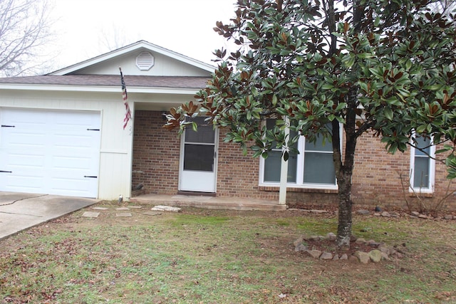 single story home featuring a garage and brick siding