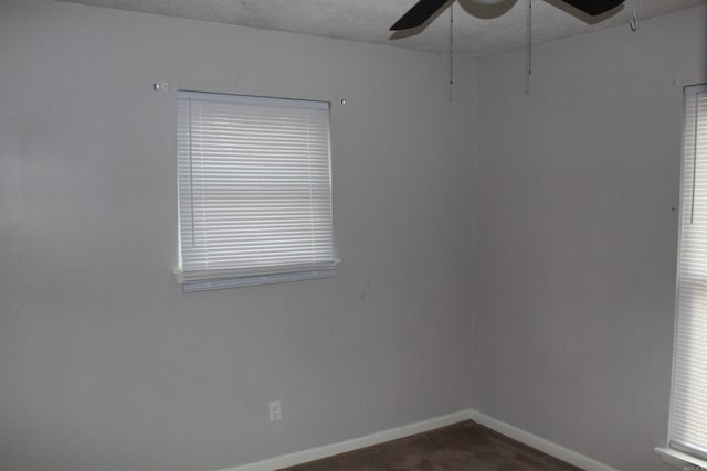 unfurnished room with ceiling fan, baseboards, and a textured ceiling