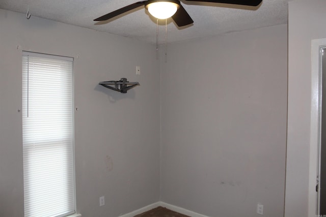 spare room featuring baseboards, a textured ceiling, and a ceiling fan