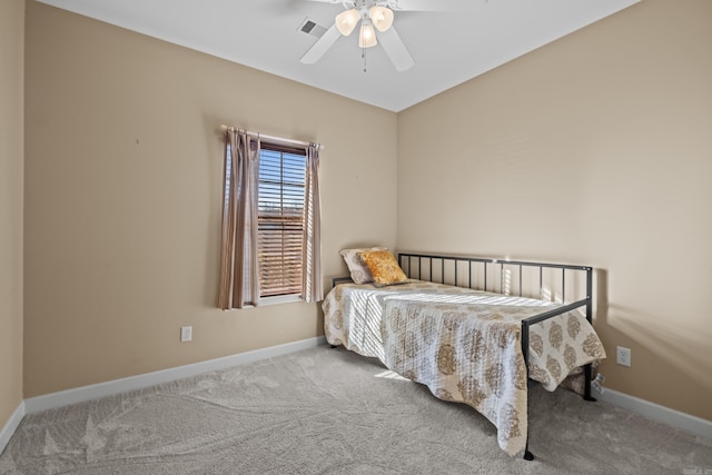 carpeted bedroom with visible vents, a ceiling fan, and baseboards