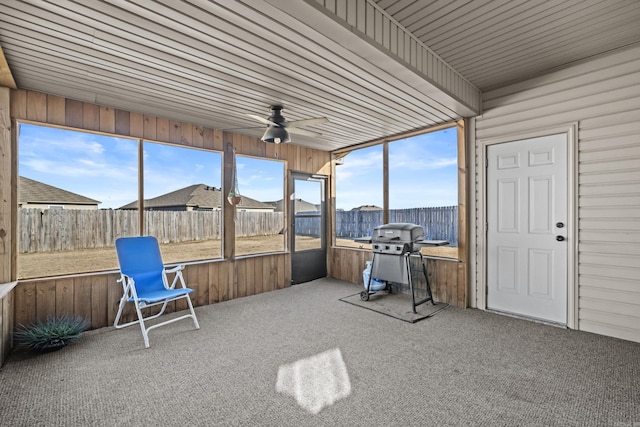 unfurnished sunroom with plenty of natural light and a ceiling fan