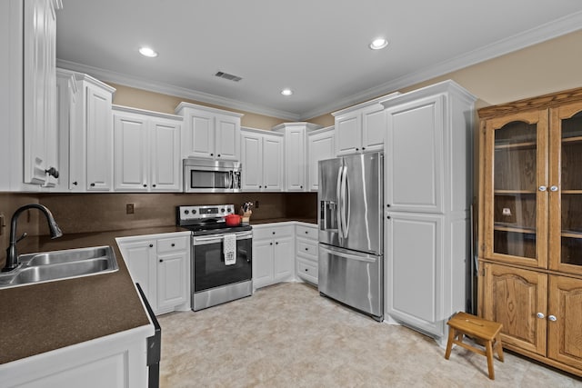 kitchen with visible vents, crown molding, stainless steel appliances, white cabinetry, and a sink