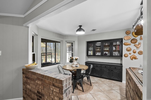 dining space with light tile patterned floors, visible vents, and ornamental molding