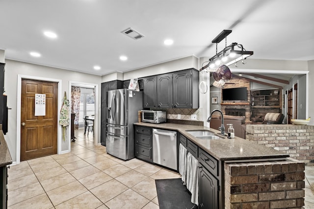 kitchen featuring visible vents, stone counters, light tile patterned flooring, a sink, and stainless steel appliances