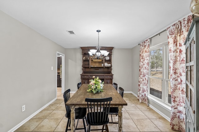 dining area featuring light tile patterned floors, visible vents, baseboards, and an inviting chandelier