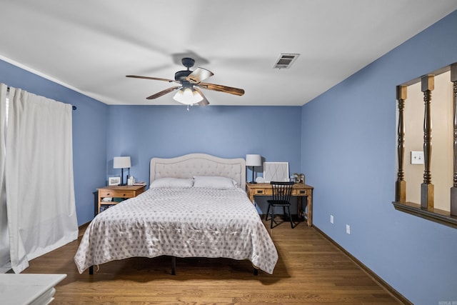 bedroom featuring visible vents, baseboards, a ceiling fan, and wood finished floors