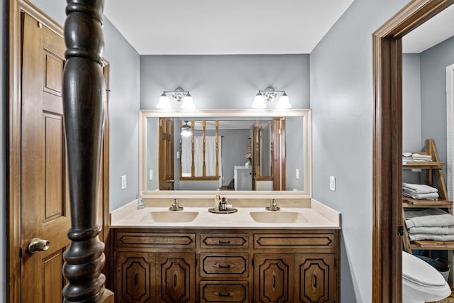 bathroom featuring a sink, toilet, and double vanity