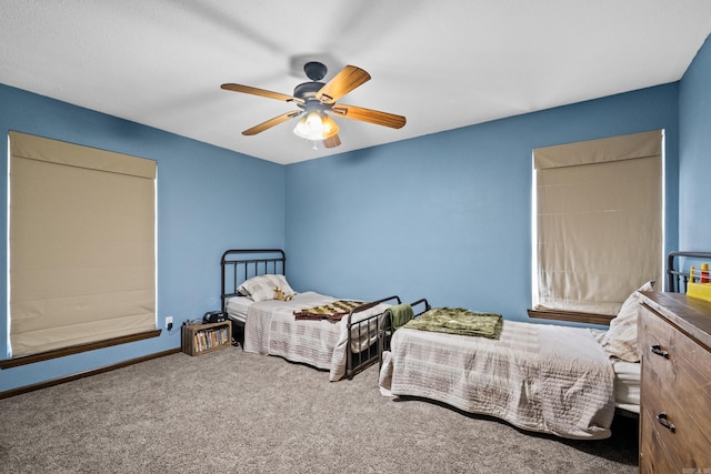 carpeted bedroom with a ceiling fan and baseboards