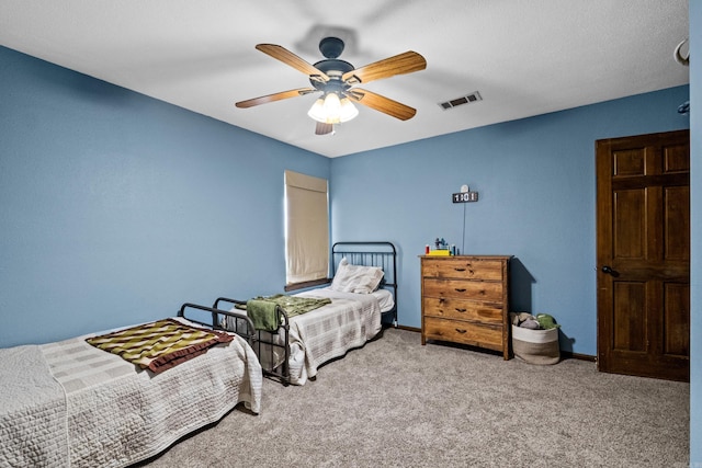 carpeted bedroom featuring baseboards, visible vents, and ceiling fan