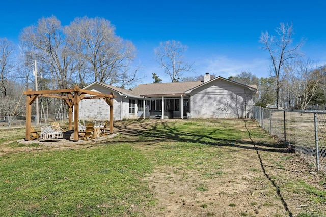 rear view of house featuring a yard, a fenced backyard, a sunroom, and a chimney