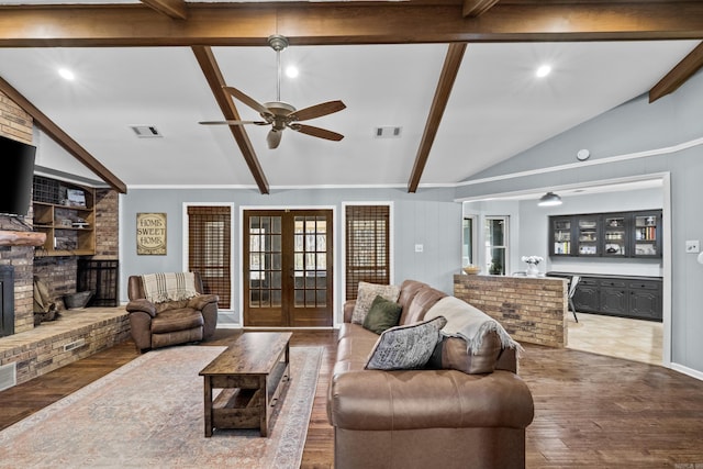 living area with visible vents, wood finished floors, french doors, a fireplace, and vaulted ceiling with beams